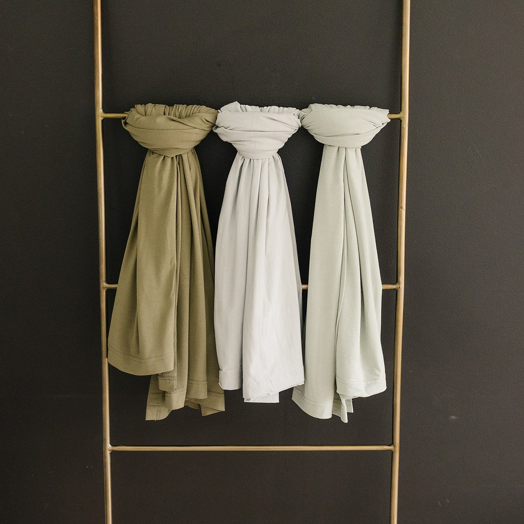 Olive Bamboo Stretch Swaddle by Mebie Baby, styled with matching nursery decor.