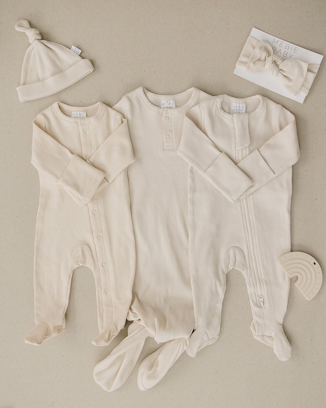 Organic cotton footie pajama for babies, the Vanilla Organic Cotton Ribbed Snap zipped up on a smiling infant.