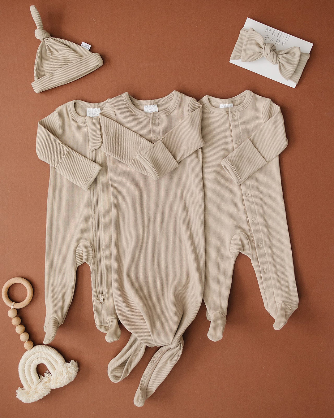 Organic cotton footie pajama for babies, the Oatmeal Organic Cotton Ribbed Snap zipped up on a smiling infant.
