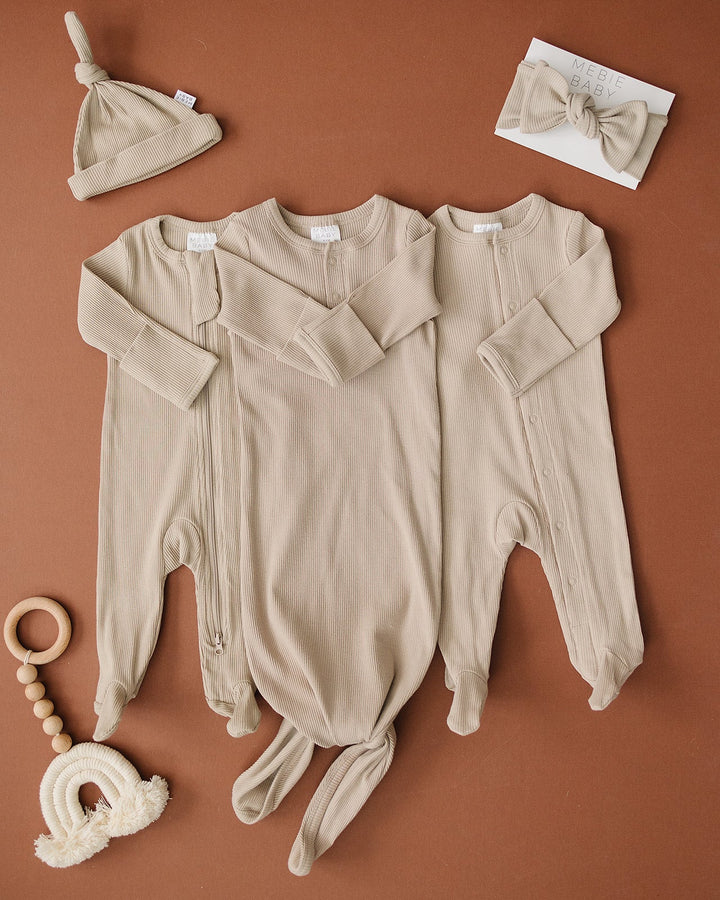 Organic cotton footie pajama for babies, the Oatmeal Organic Cotton Ribbed Snap zipped up on a smiling infant.