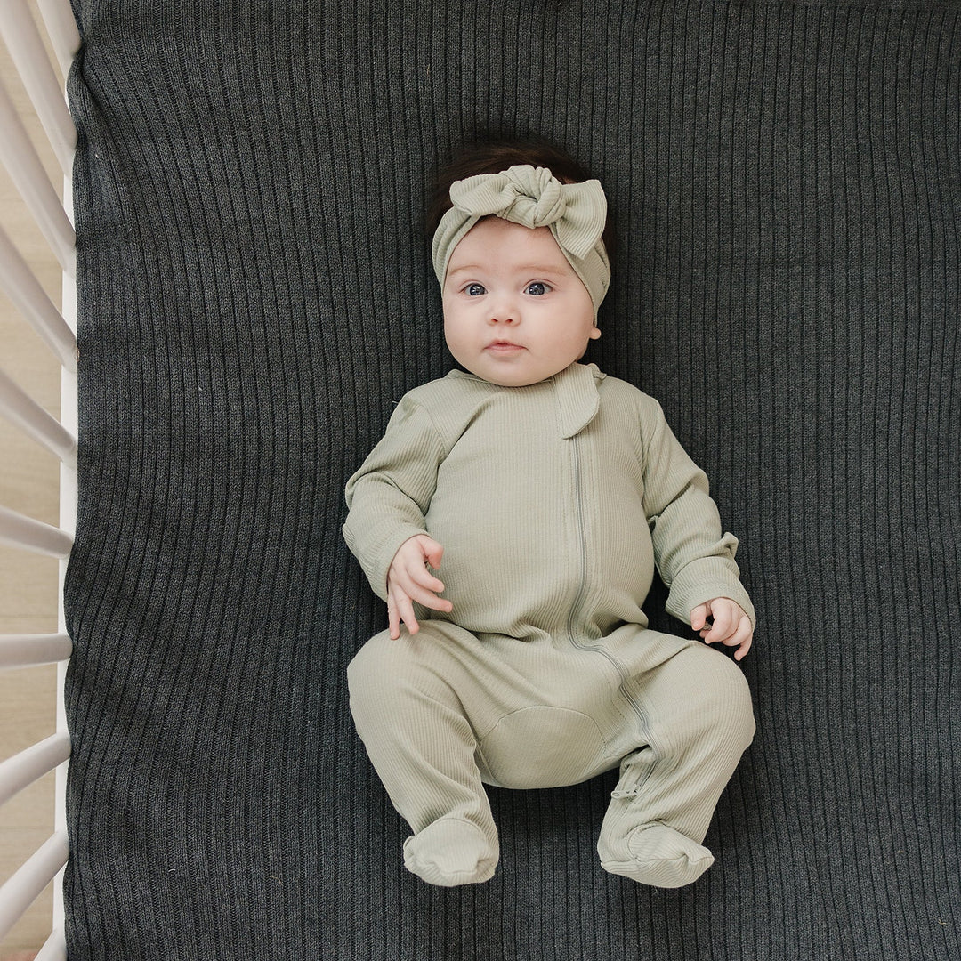 Organic cotton footie pajama for babies, the Sage Organic Cotton Ribbed Zipper zipped up on a smiling infant.