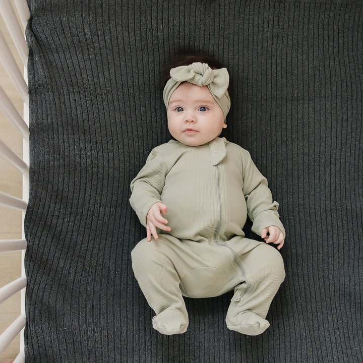 Organic cotton footie pajama for babies, the Sage Organic Cotton Ribbed Zipper zipped up on a smiling infant.