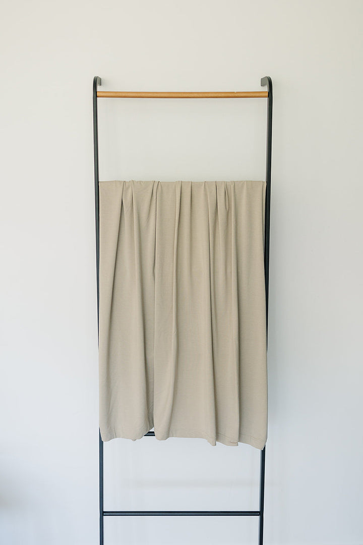 Shop swaddle blankets at Mebie Baby now, the Oatmeal Bamboo Stretch Swaddle styled with matching nursery decor.
