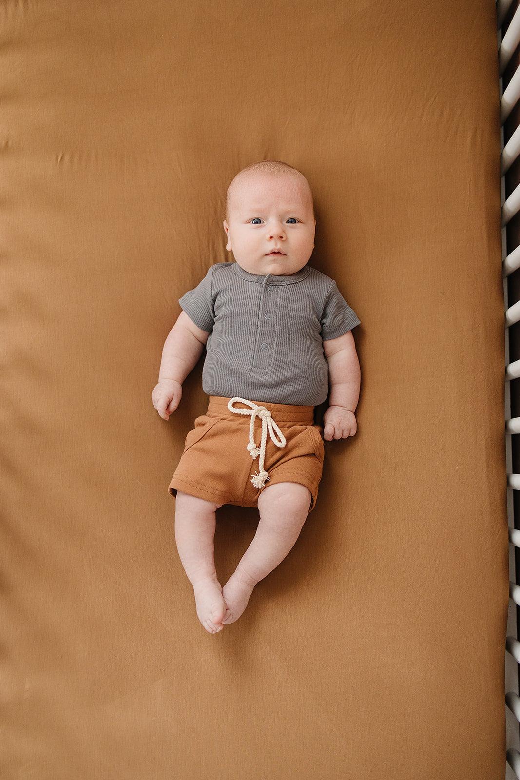 Laid flat to show the ribbed fabric, the Grey Organic Cotton Ribbed Snap Bodysuit from Mebie Baby.