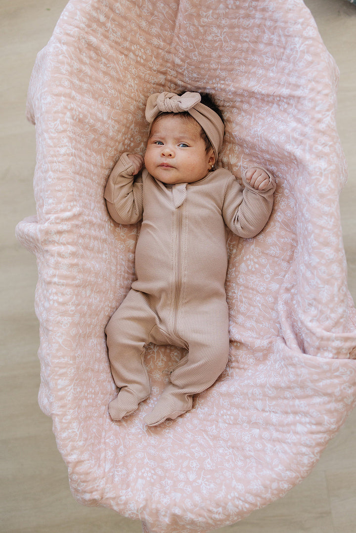 Laid flat to show the ribbed fabric, the Pale Pink Organic Cotton Ribbed Zipper from Mebie Baby.