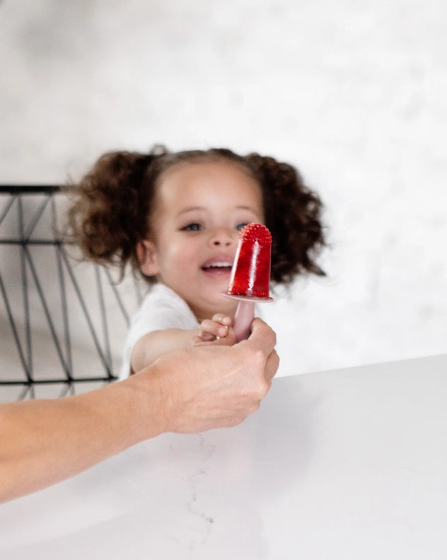 Little hands grab the Blush EZPZ Happy Pops, a playful baby silicone feeding set perfect for early snacking