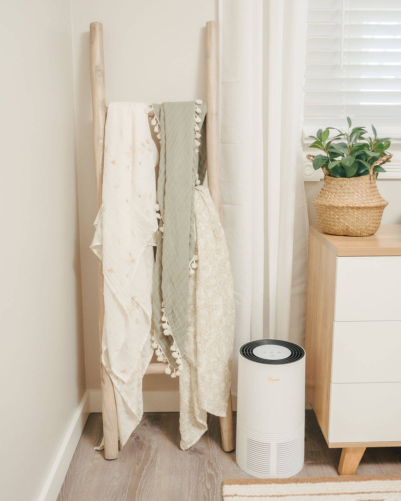 three soft green sage and neutral baby swaddles in crane baby modern nursery 