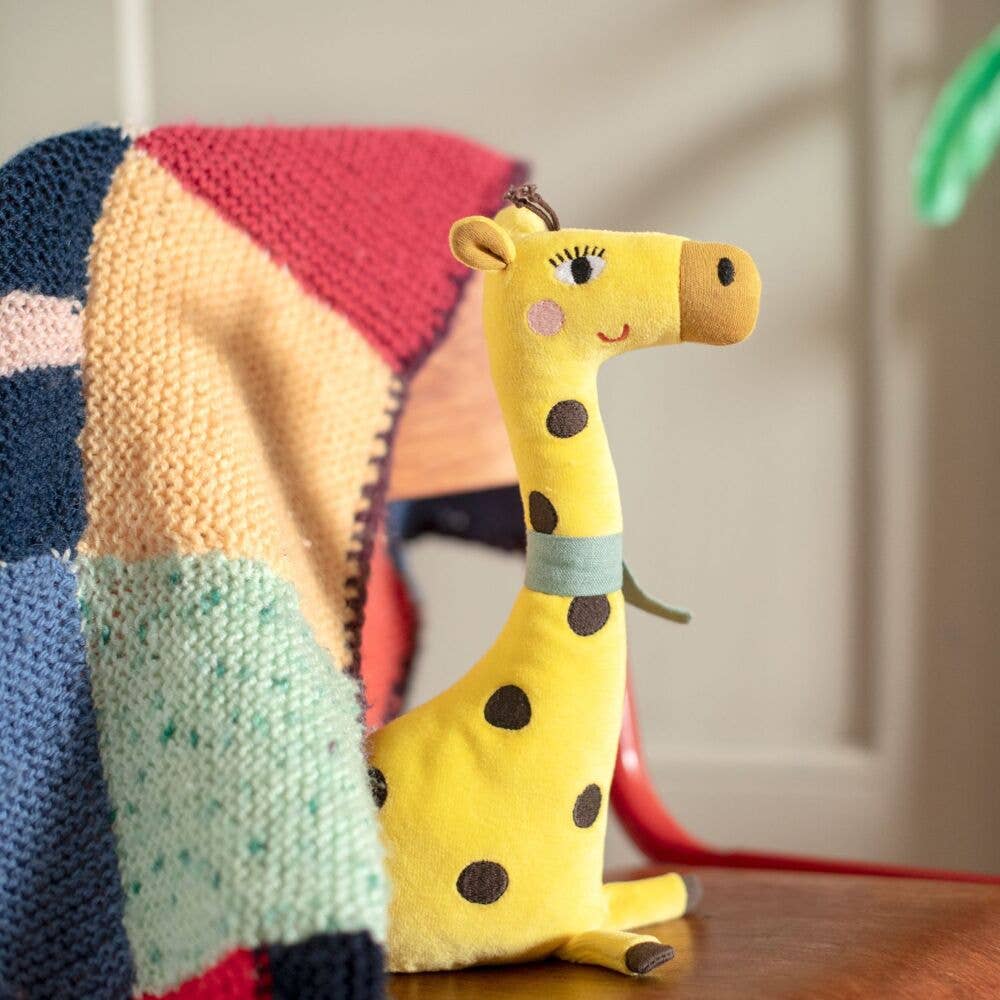 Giraffe Rattle The Toupitis Plush giraffe toy with a colorful blanket