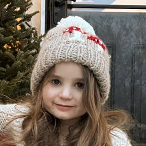 Kid wearing the Mushroom Hand Knit Beanie Hat, gender neutral winter hat with pom pom