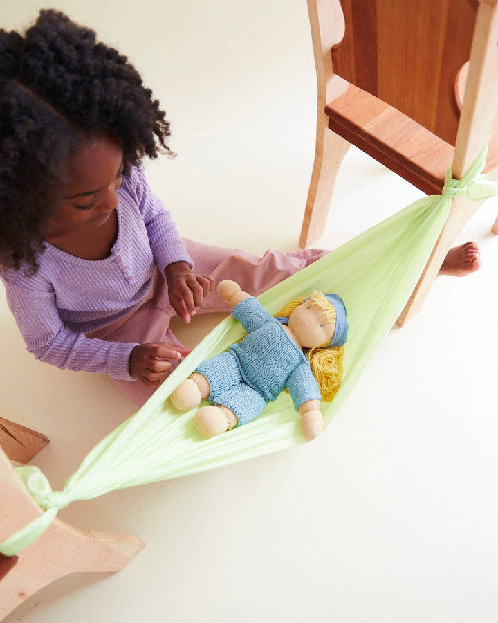 Green Sarah's Silks Solid Color Playsilk used as a pretend play hammock, beloved by little ones