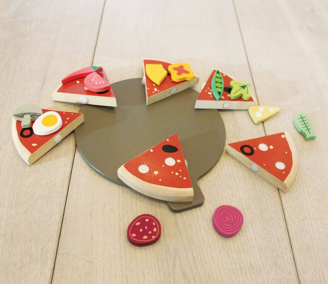 Wooden pizza slices and toppings scattered across a light floor for imaginative play