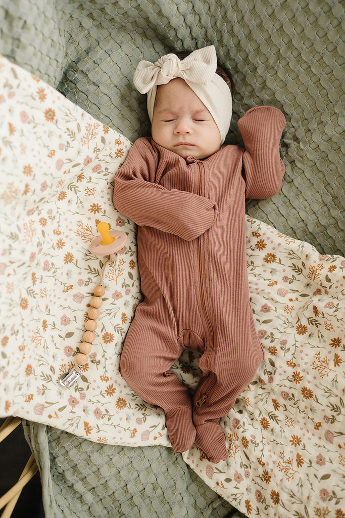 Baby sleeping in the Mebie Baby organic cotton footed one piece