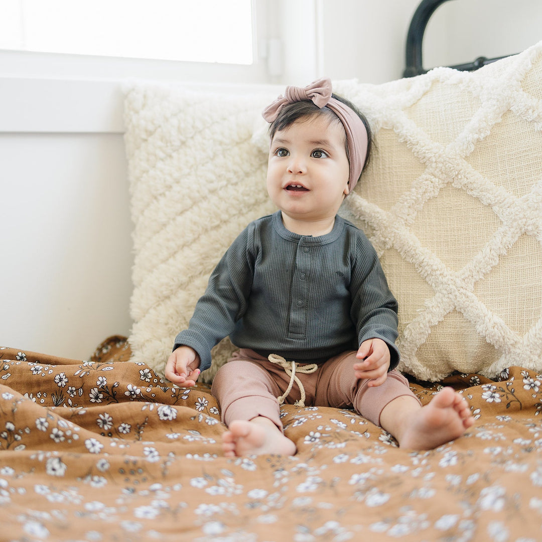 Laid flat to show the ribbed fabric, the Charcoal Organic Snap Long Sleeve Ribbed Bodysuit from Mebie Baby.