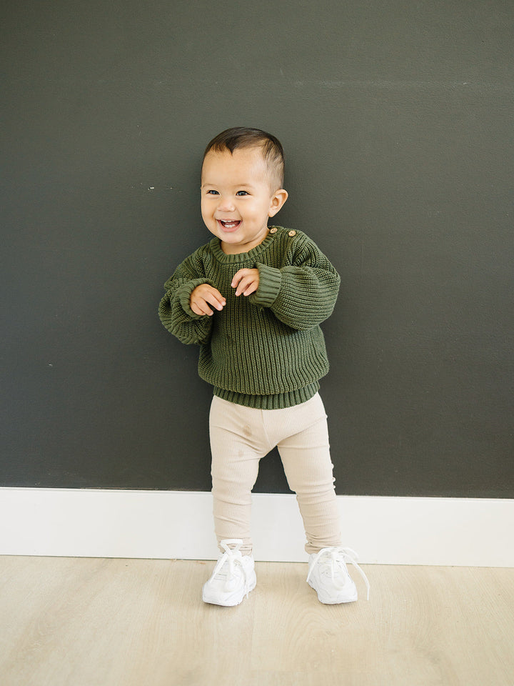 Oatmeal Organic Leggings from Mebie Baby, folded on a wooden shelf.