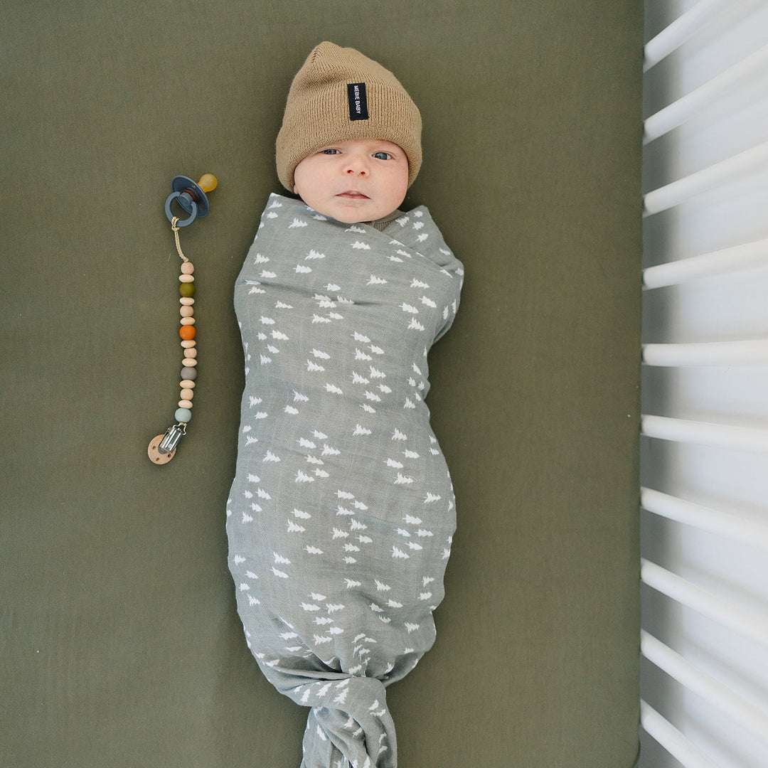 Breathable bamboo swaddle blanket for newborns, the Pines Muslin Swaddle Blanket shown in a flat lay to highlight the fabric.