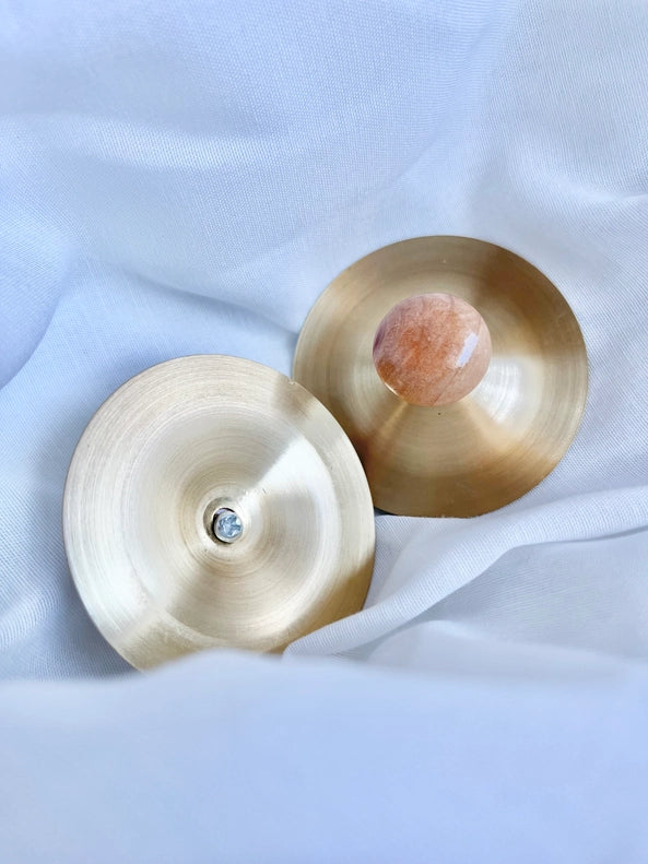 Captured in a playful scene, the All Wooden Elements Pair of 2 Petit Cymbals serves as gentle musical toys for infants.