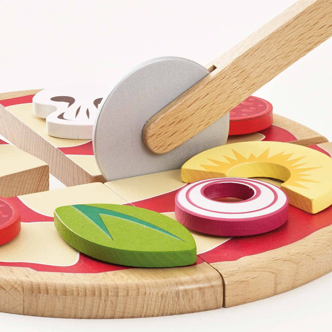 The wooden slicer glides through a pizza slice layered with mushroom and onion from Le Toy Van