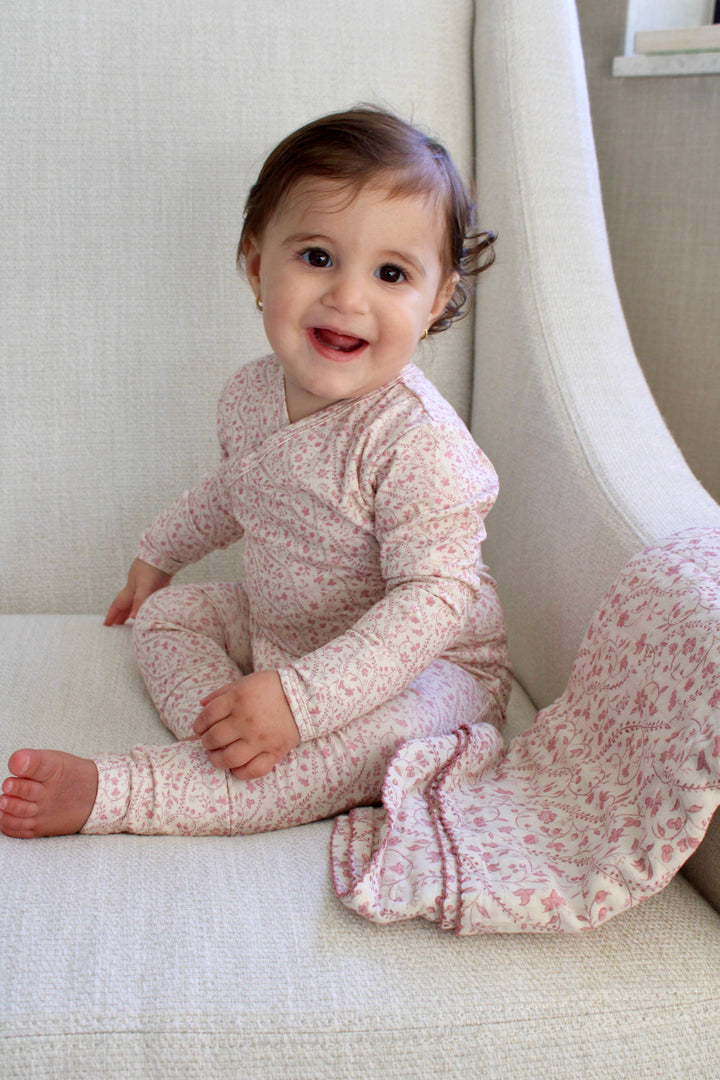 Little Threads baby wrap footie worn while sitting on a cozy blanket