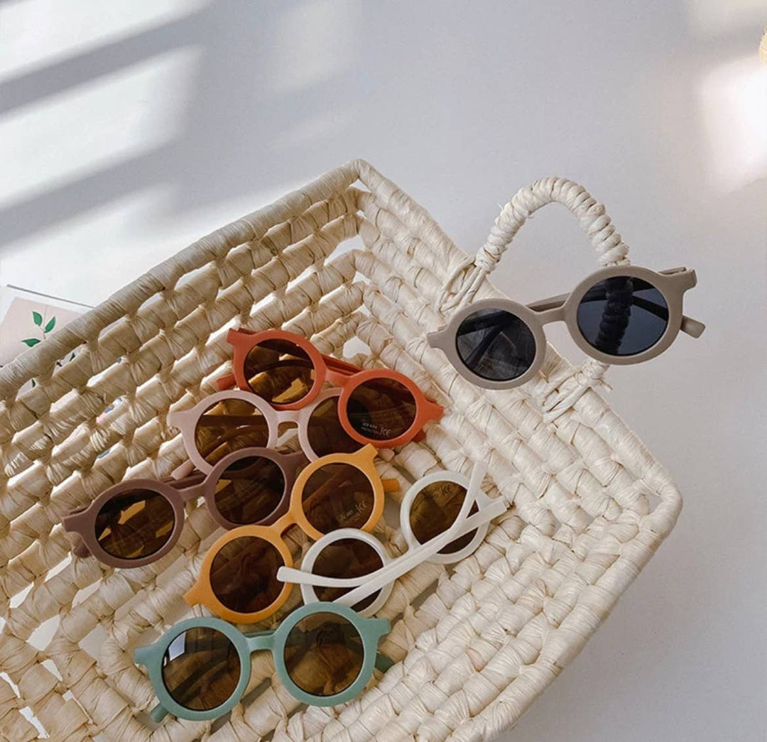 boho + babe basket for of their baby and toddler sun safe sunglasses in orange, red, green, and beige 