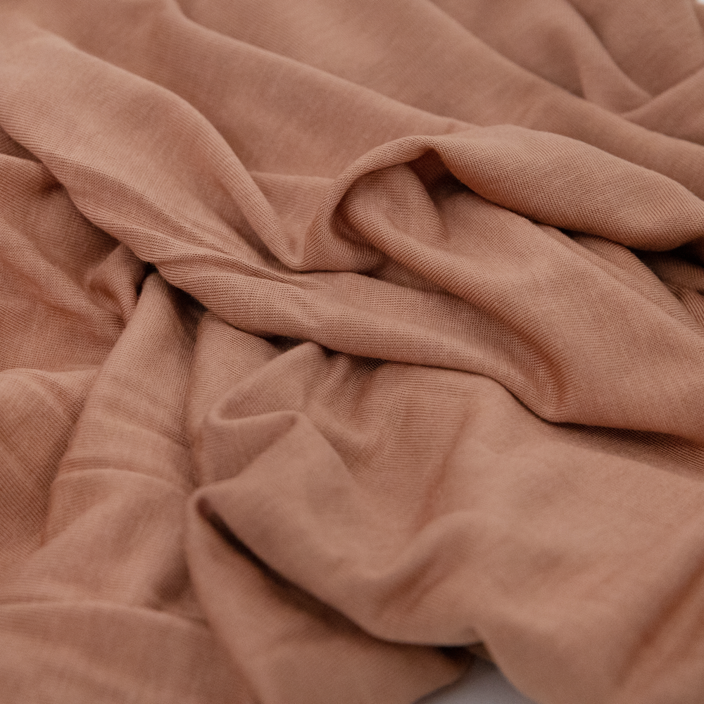 Wrap your baby in warmth with Little Unicorn Terracotta Muslin Swaddle, perfect muslin blankets.