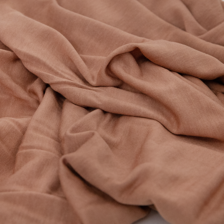Wrap your baby in warmth with Little Unicorn Terracotta Muslin Swaddle, perfect muslin blankets.