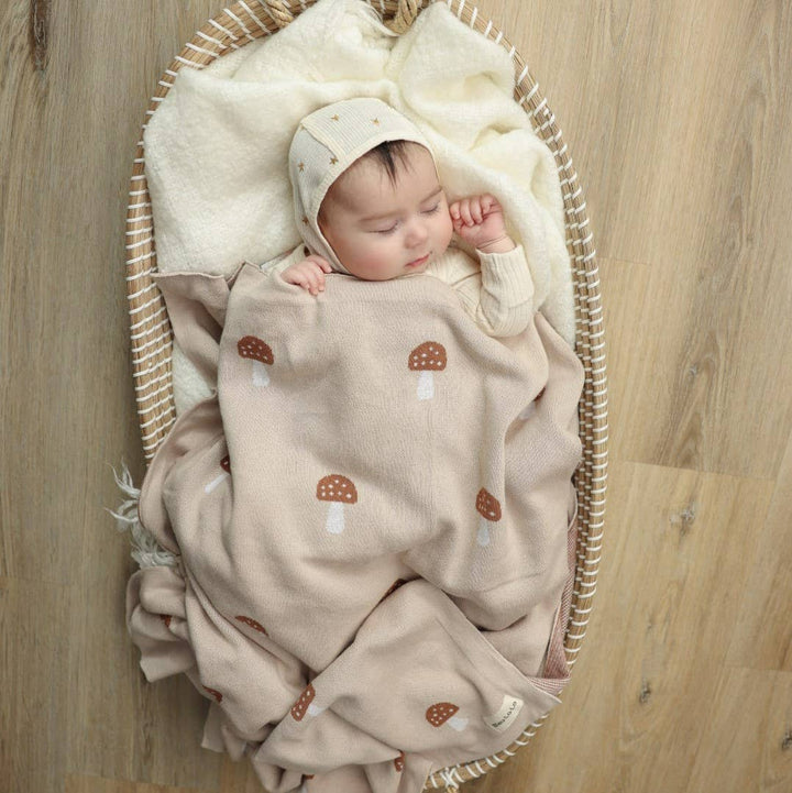 Newborn baby wrapped in Bleu La La Cotton Swaddle Receiving Baby Blanket Camel with mushroom design