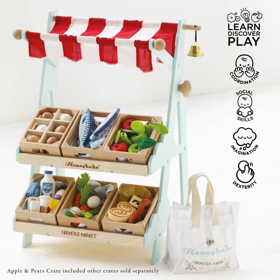 Wooden crates brimming with colorful play fruit and vegetables sit on the shelves of Le Toy Van's Market Stall