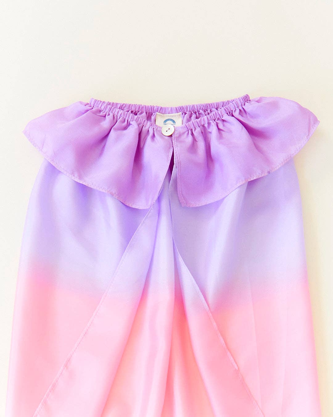 Close up flat lay of the Sarah's Silks Blossom Cape, featuring its ruffled silk collar