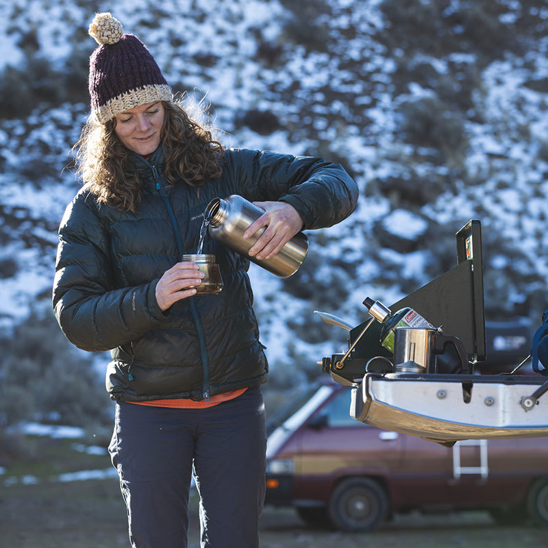 Pouring scene with Klean Kanteen 64oz Wide Water Bottle in Black, metal and chip resistant finish for durable use.