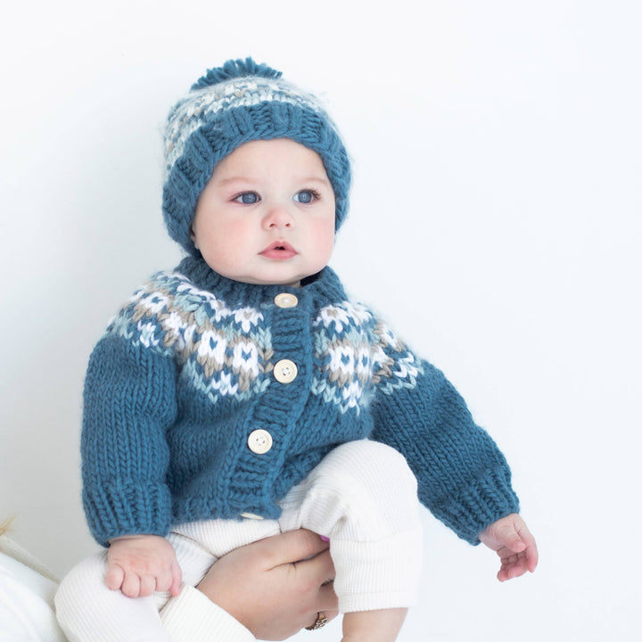 Toddler wearing Fairisle Slate hand knit sweater by Huggalugs, playful pose