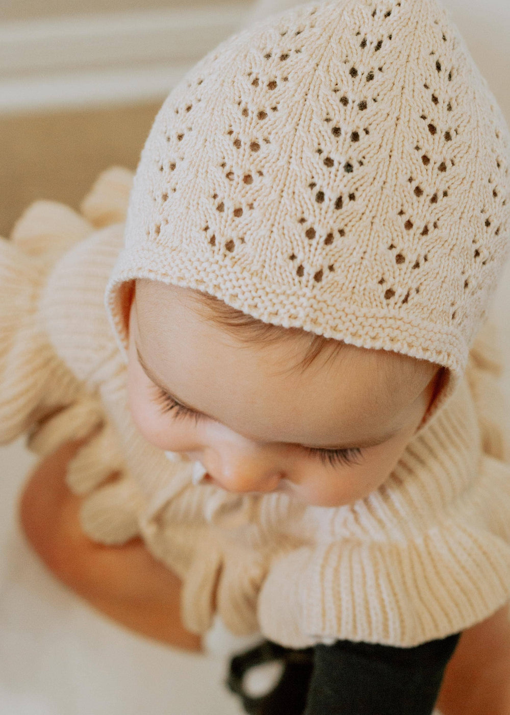 Olive & Cradle Jamie Knit Bonnet flat lay – heirloom-style hand-knit infant bonnet showing tie detail