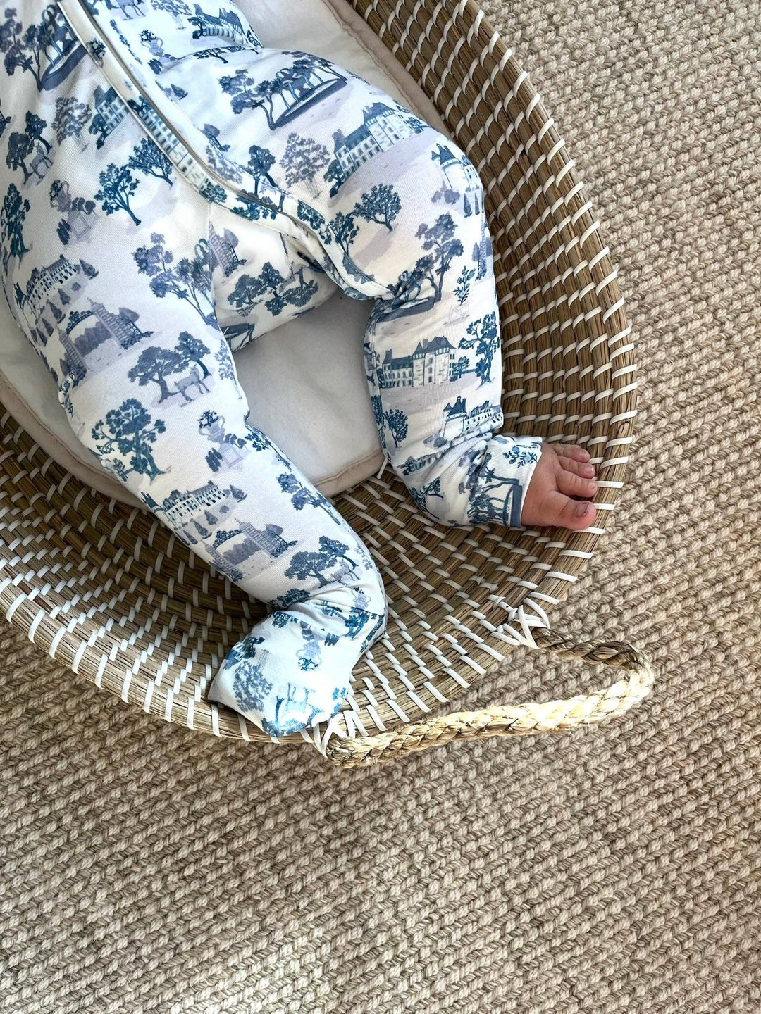 Close up of Little Threads footie pajama feet and legs in a woven basket