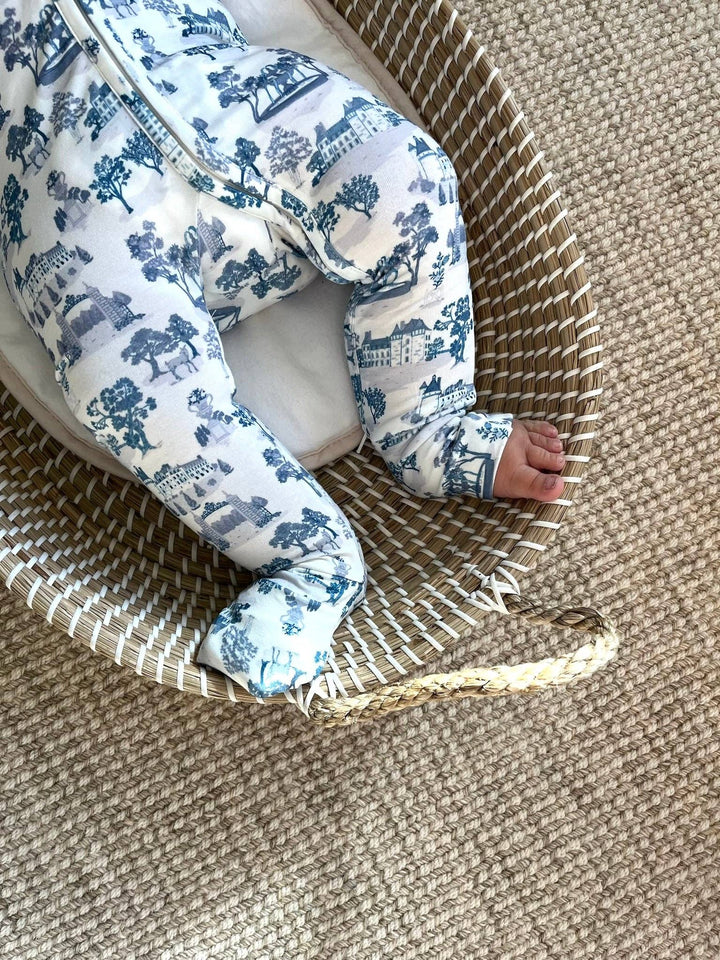 Close up of Little Threads footie pajama feet and legs in a woven basket
