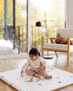 Little girl stacking blocks on the Piccalio play mat.