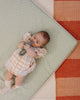 Baby laying on Piccalio waterproof play mat.