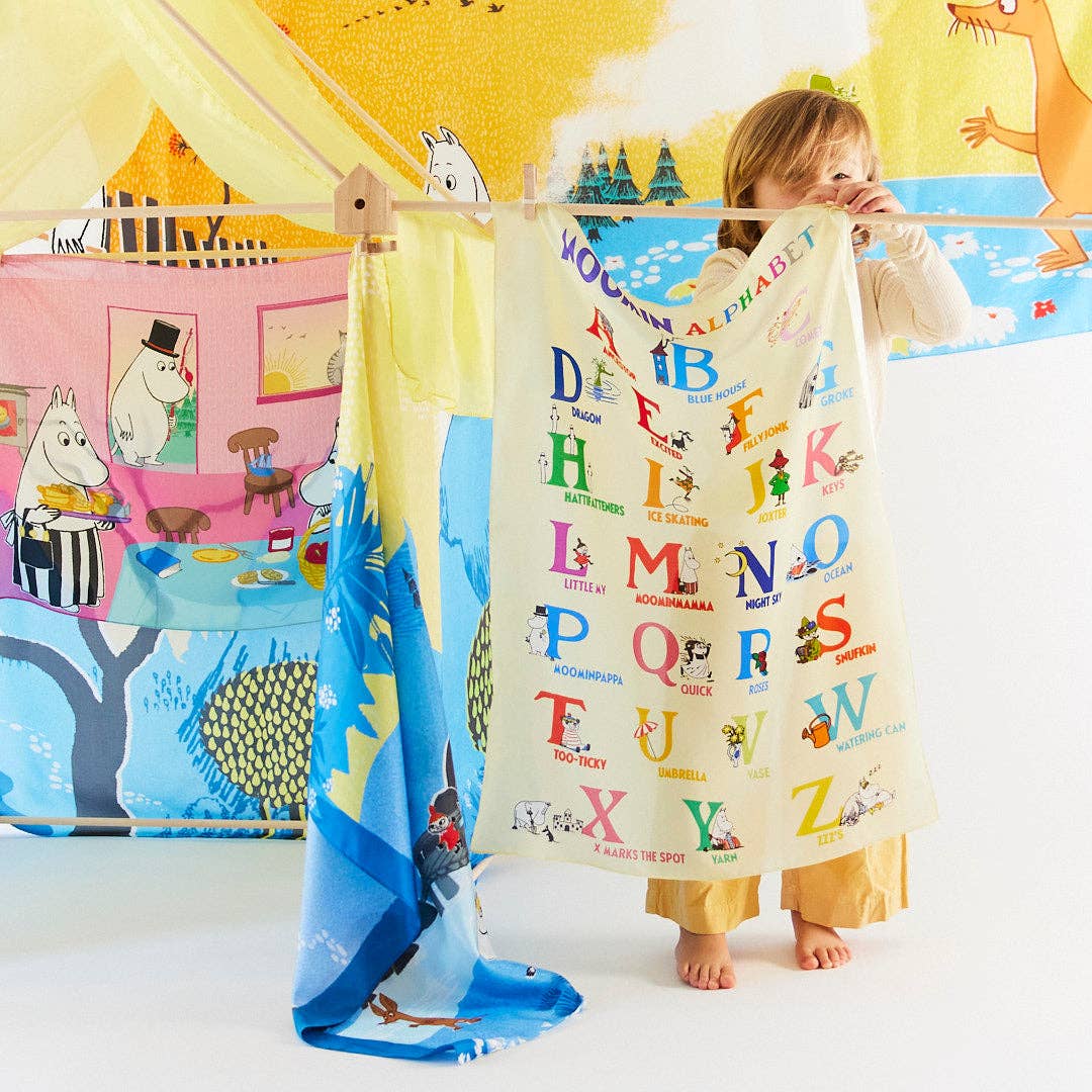 A child adjusts the Moomin Alphabet Playsilk canopy, blending learning with imaginative play
