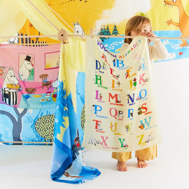 A child adjusts the Moomin Alphabet Playsilk canopy, blending learning with imaginative play