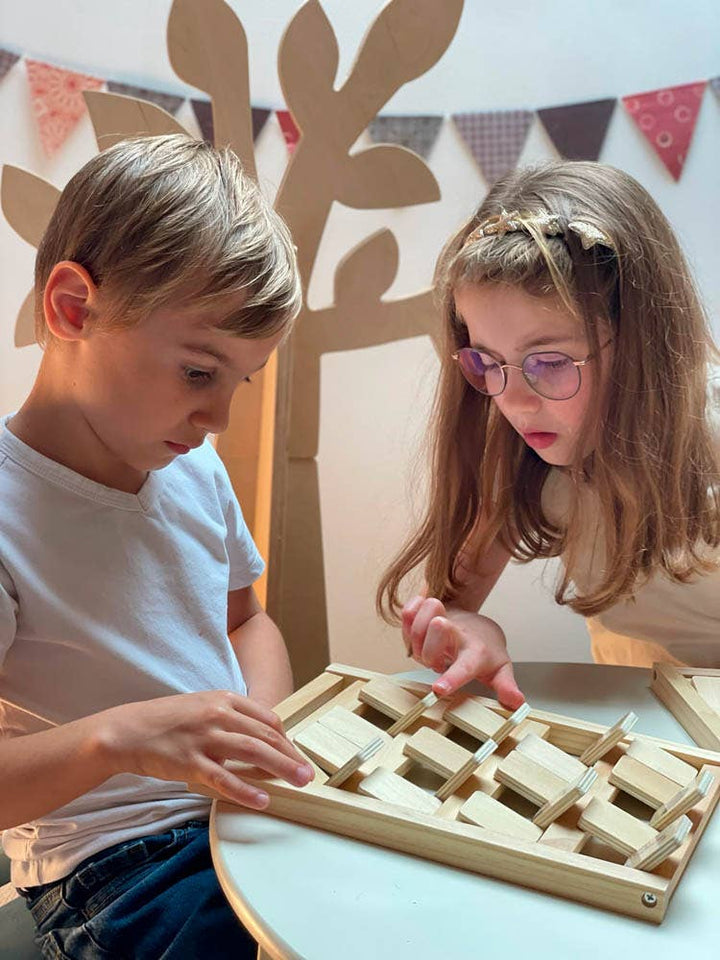 Two kids work together fitting tiles into place during a Who Am I session from Egmont