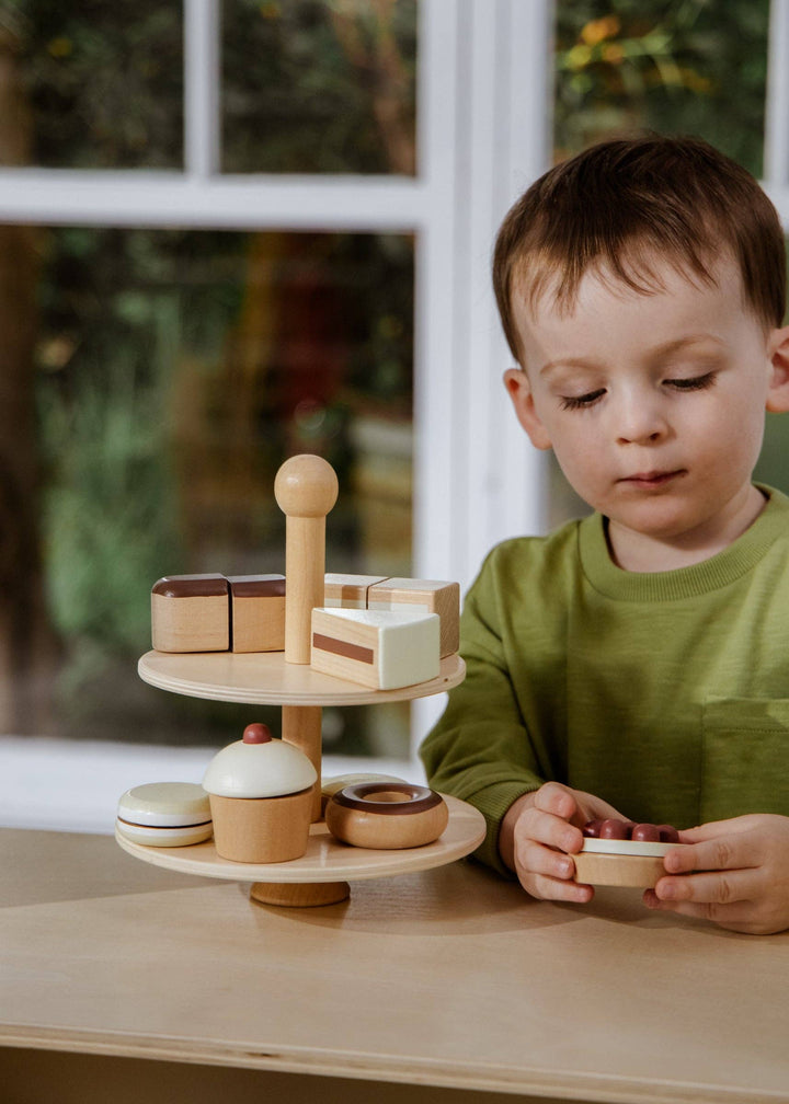 The Coco Village Wooden Desserts Tower features beautifully painted wooden pieces that inspire pretend bakery and kitchen play.