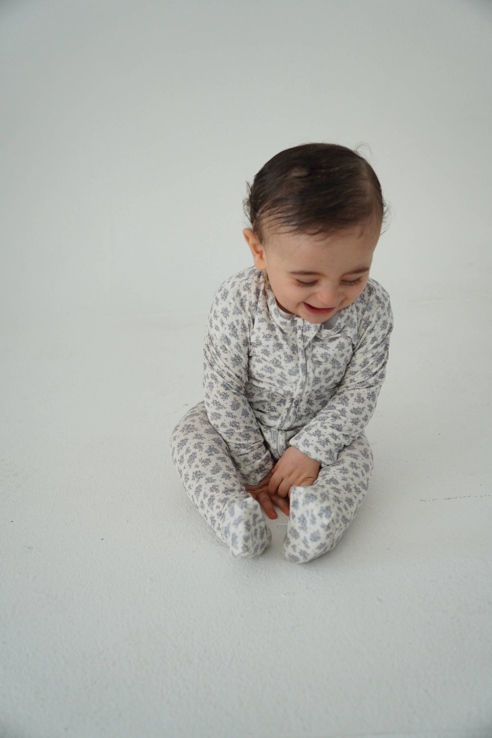 Baby sitting in Little Threads vintage blue floral bamboo pajamas, breathable baby sleepwear for sensitive skin and cozy everyday wear