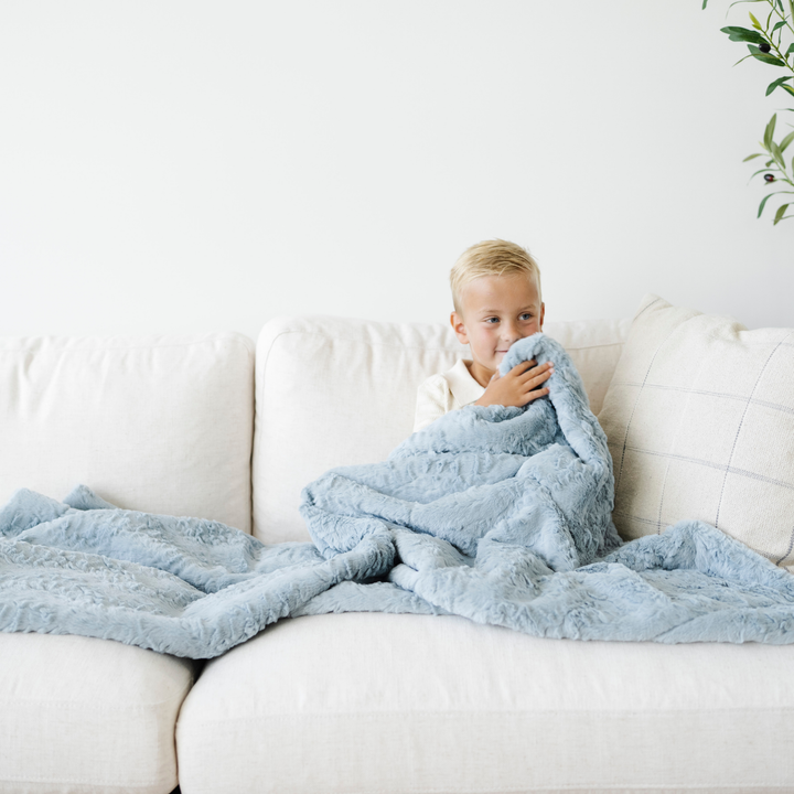 The Saranoni Dream Toddler Blanket in Heather Blue provides gentle coziness, a beautiful choice for baby girl blankets.