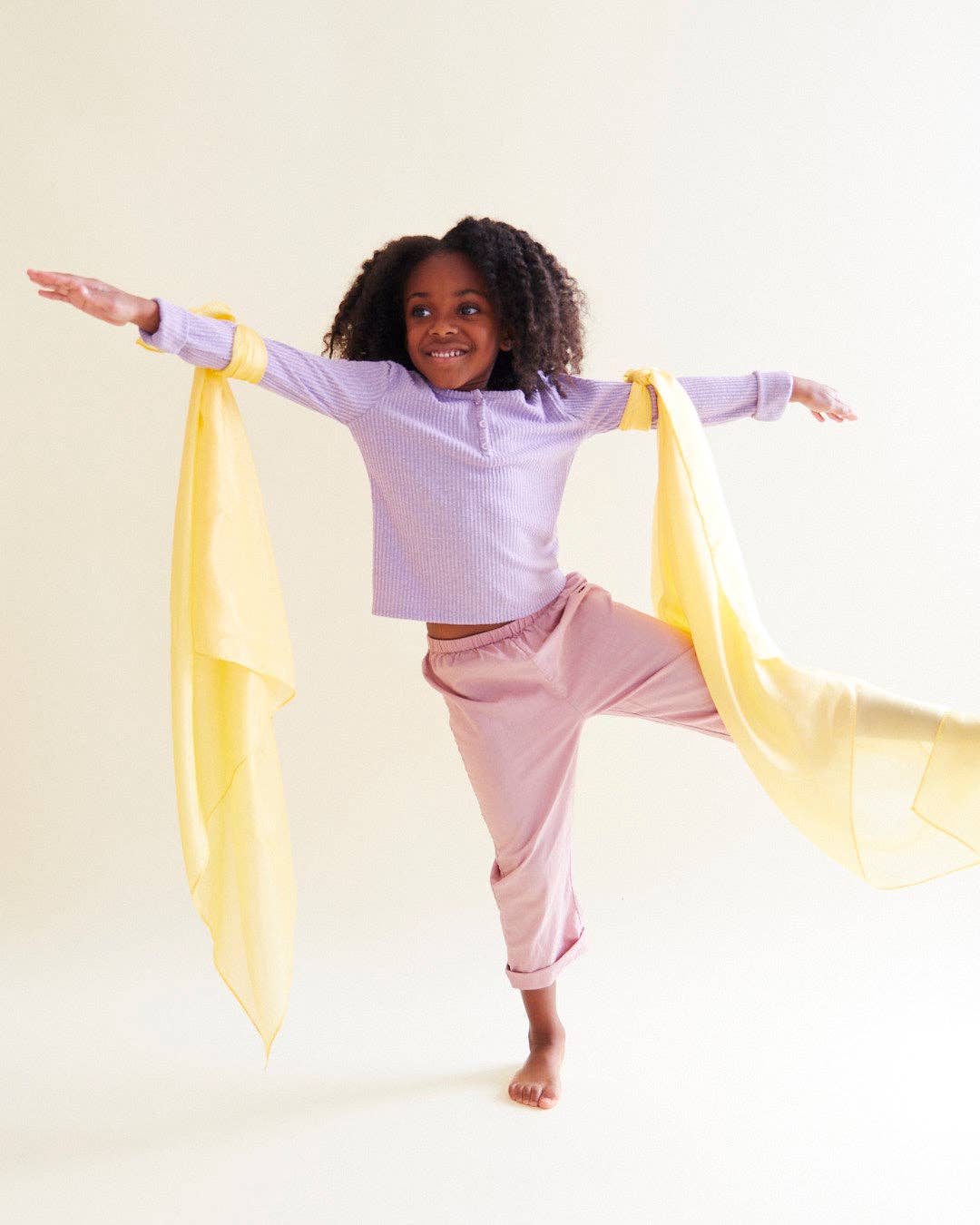 A top rated kids toy in motion, child dancing with a yellow Sarah's Silks Solid Color Playsilk