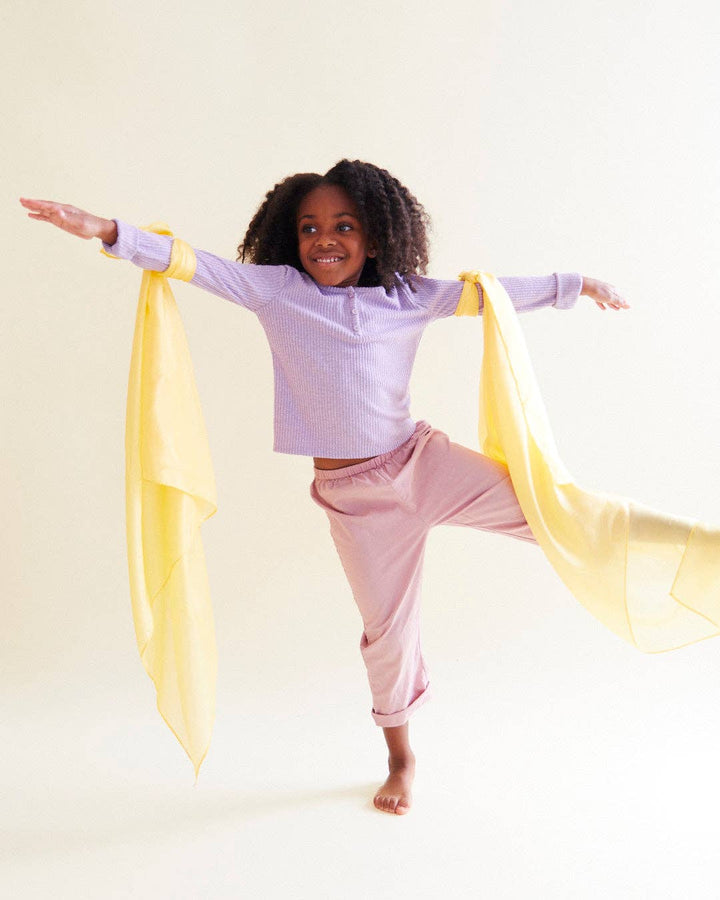 A top rated kids toy in motion, child dancing with a yellow Sarah's Silks Solid Color Playsilk
