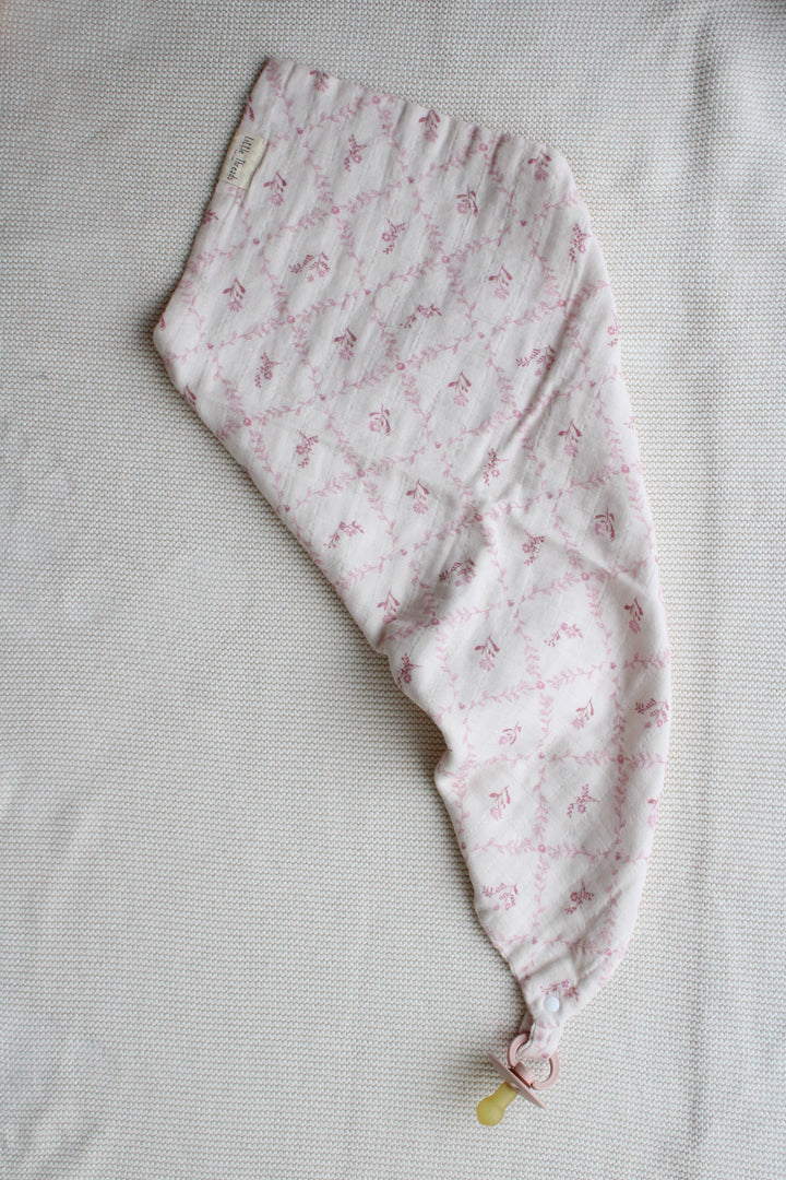 Mauve lattice lovey blanket by Little Threads draped diagonally with pacifier clip holder