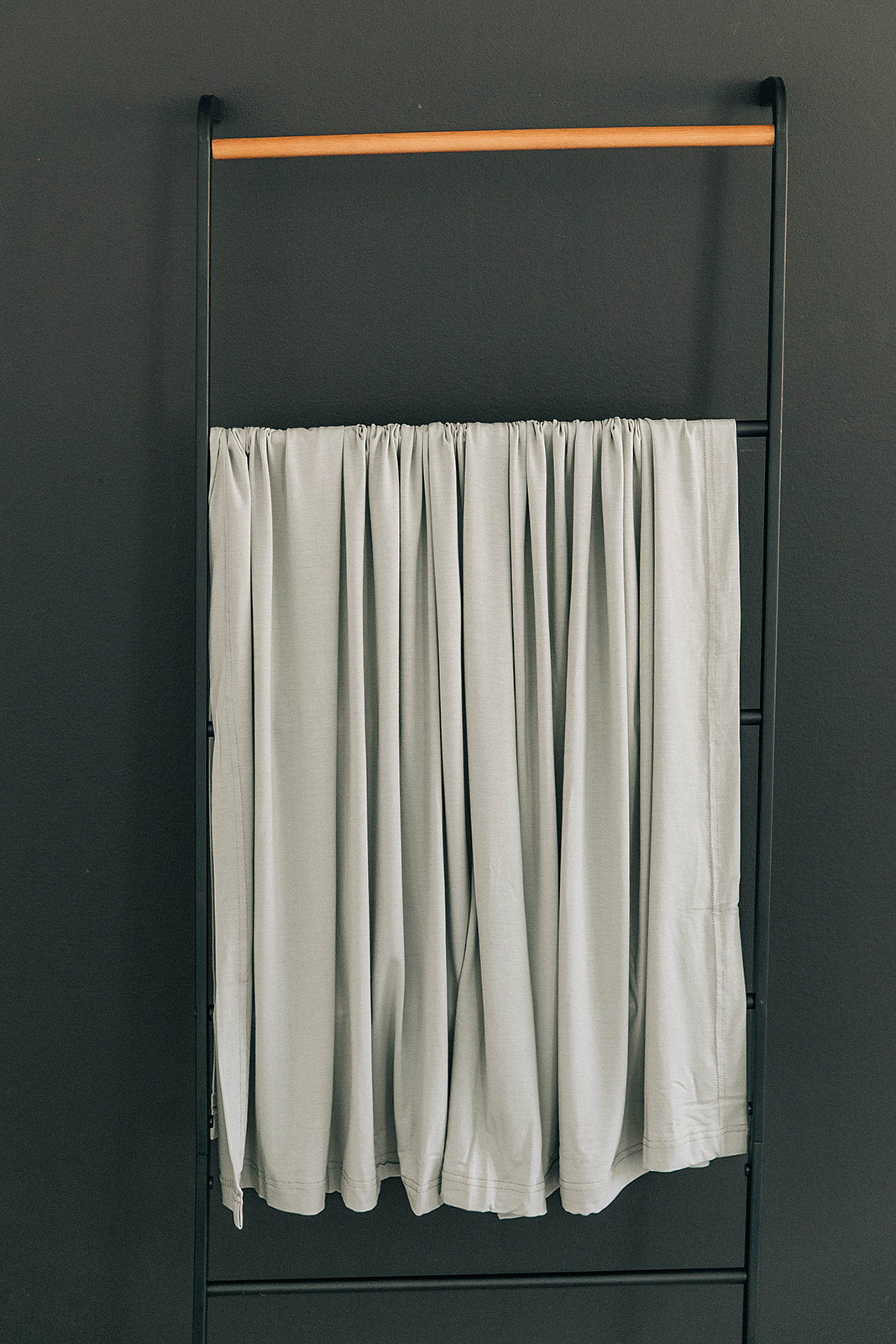 Sage Bamboo Stretch Swaddle by Mebie Baby, styled with matching nursery decor.