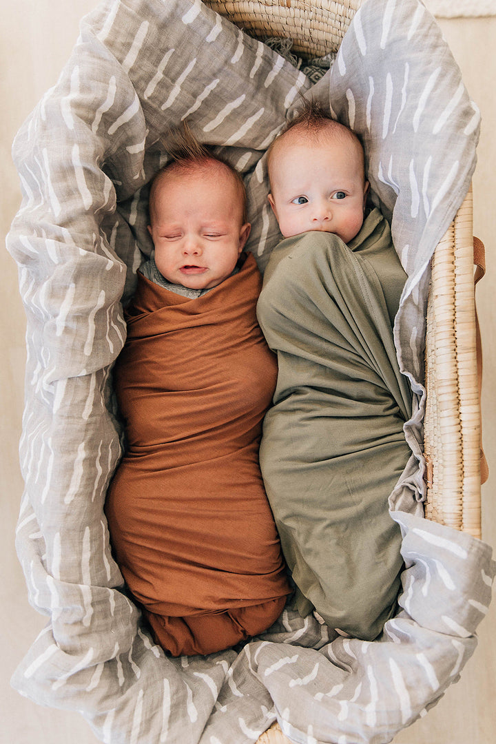 Olive Bamboo Stretch Swaddle from Mebie Baby, shown in a flat lay to highlight the fabric.
