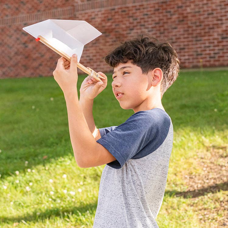 Child launching a paper airplane with Huckleberry launcher