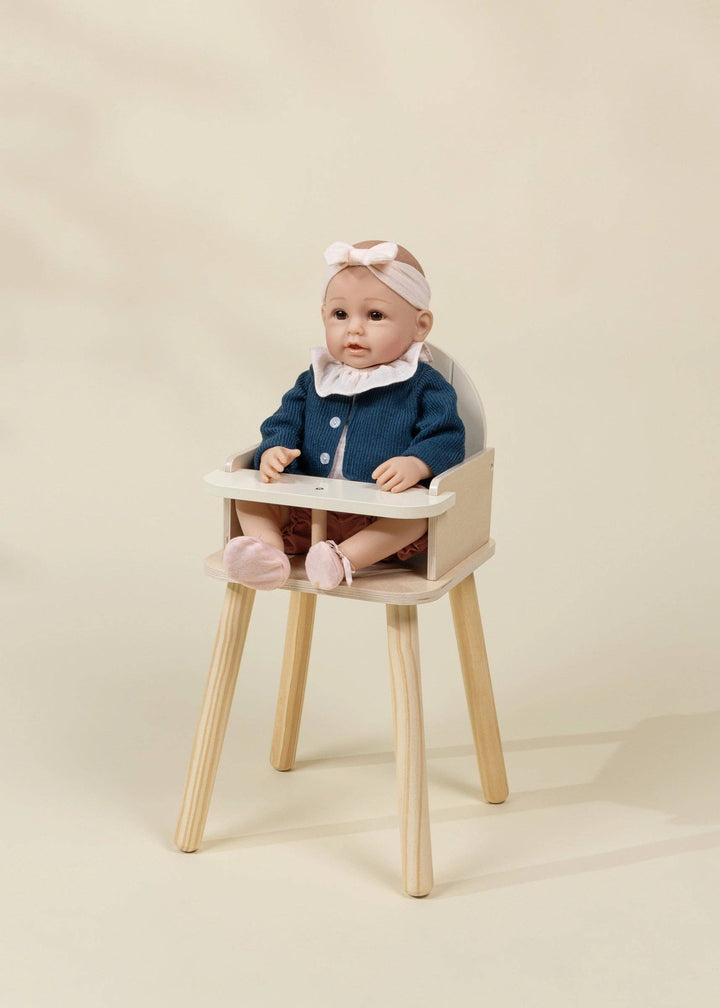 Wooden Dolls' High Chair holding a baby doll at mealtime, a Coco Village pretend play favorite