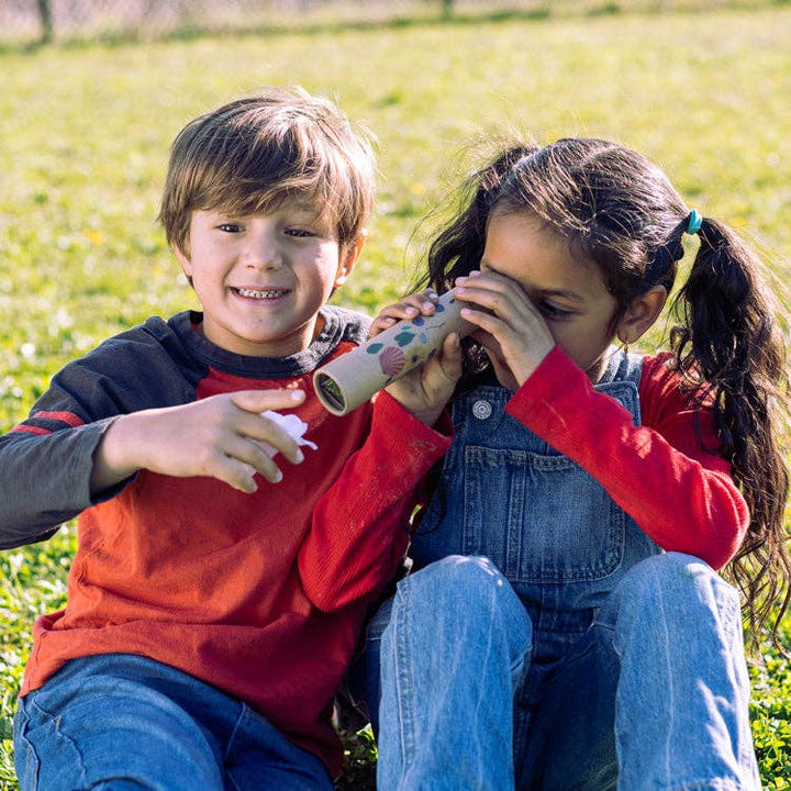 two children using Huckleberry Kaleidoscope nature toy outside 