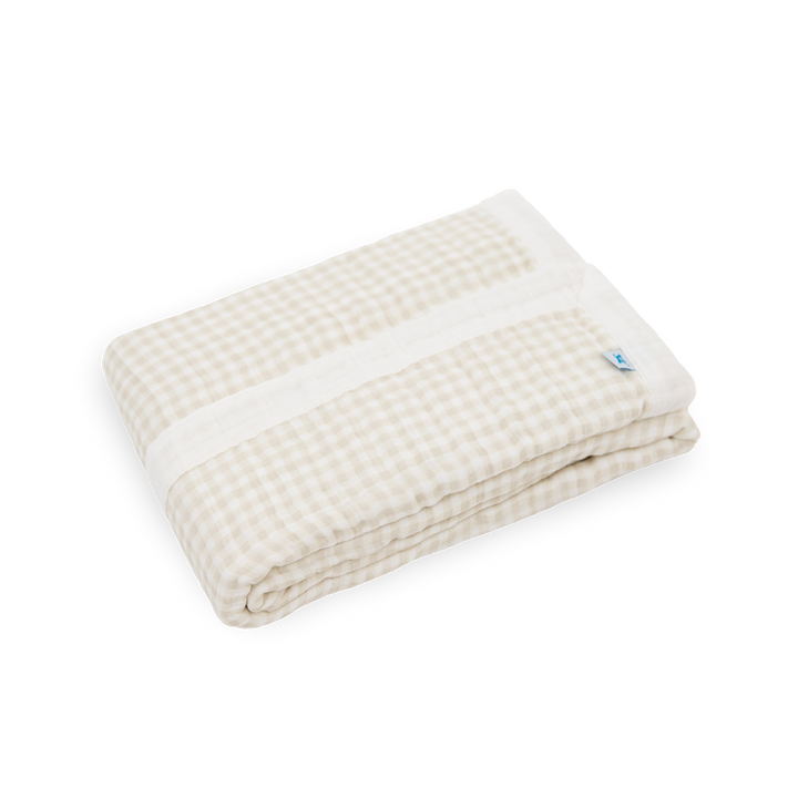 Close-up of Little Unicorn Cotton Muslin Baby Quilt - Tan Gingham showing lightweight muslin fabric and timeless gingham design.